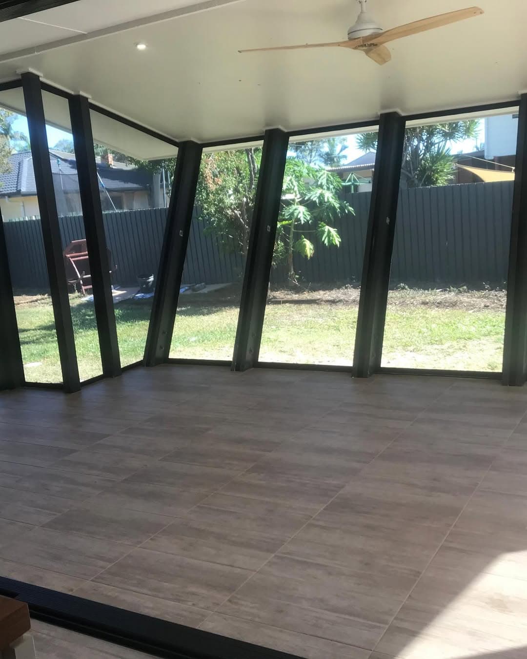 Inside the enclosed room with tiled floors, finished ceiling and a timber ceiling fan
