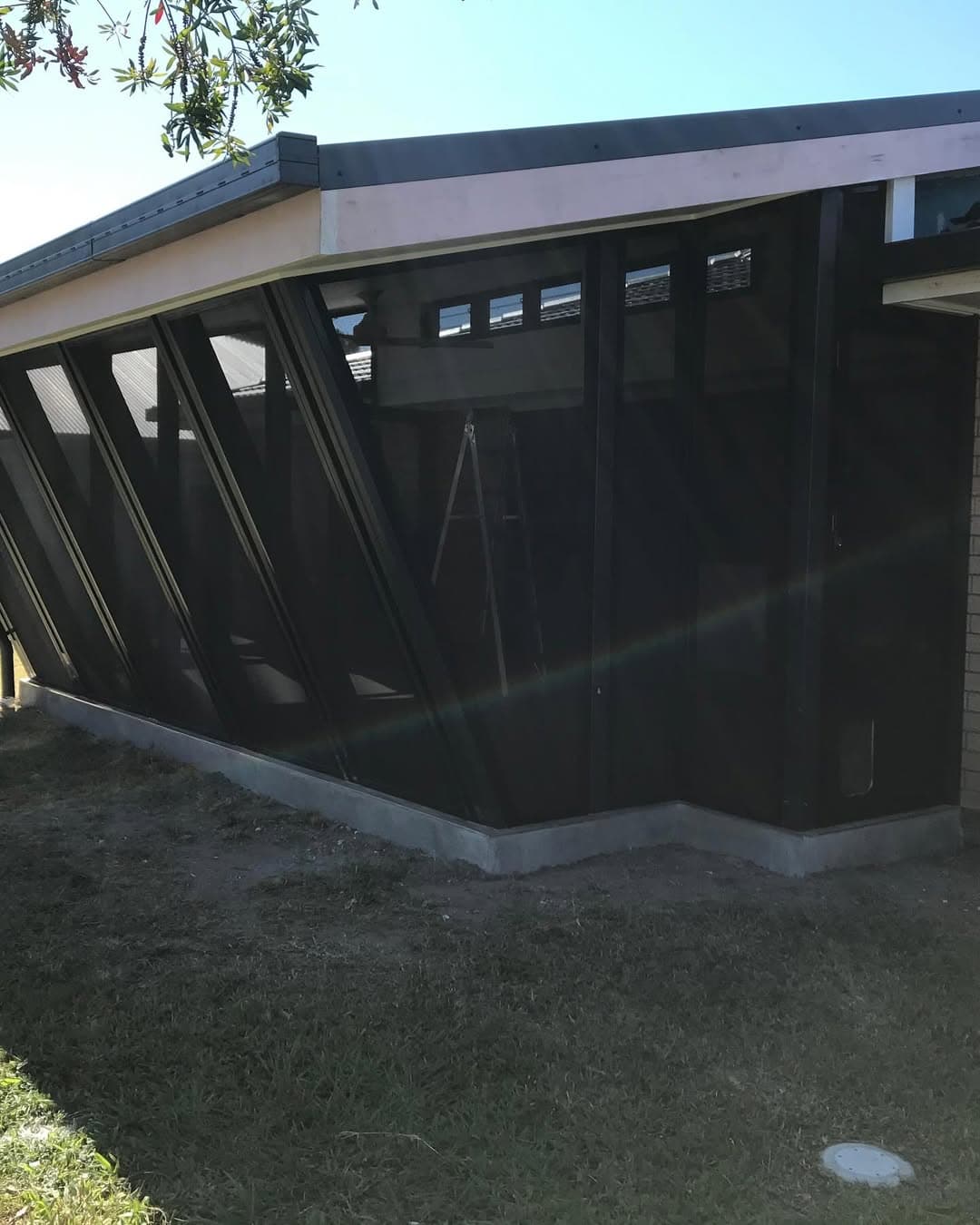 The same angled frame fitted with dark screens to enclose the new room